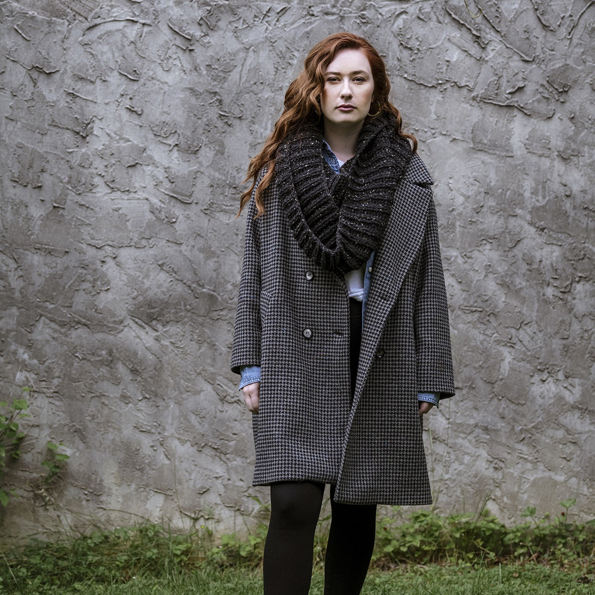 Red haired female wearing a Lucky Tweed donegal merino wool fisherman's rib bulky cowl in 006 black.