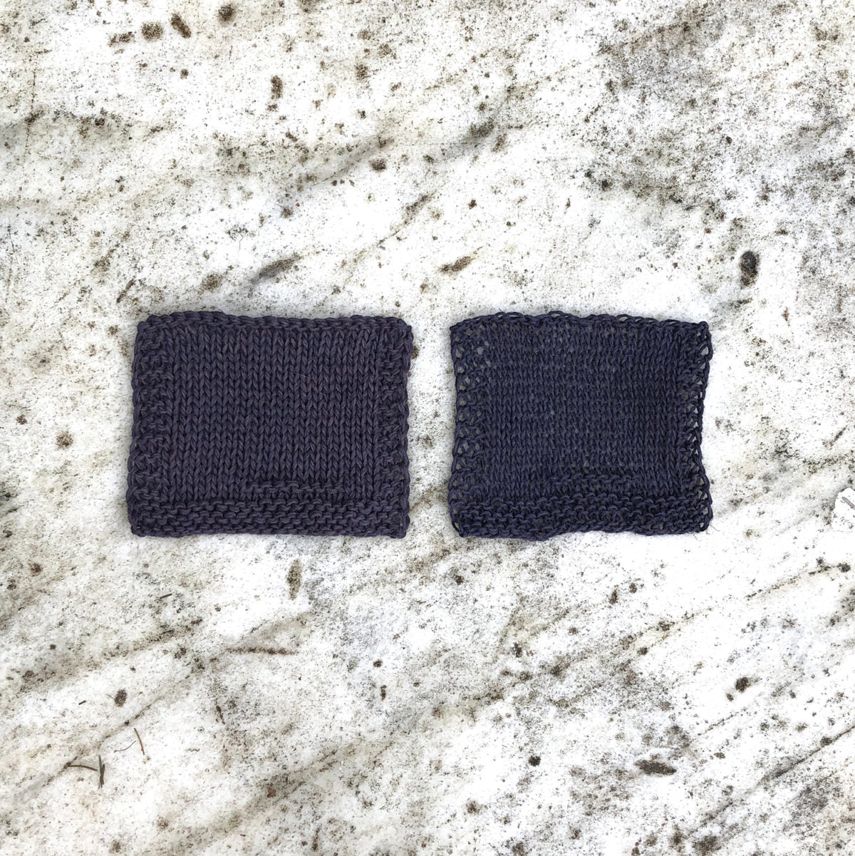 Two rectangular Kelbourne Woolens Mojave swatches before washing photographed on a textured marble background